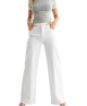 WOMAN wearing white wide-leg pants and a gray top on a white background