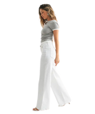 Woman wearing a gray t-shirt and white pants on a white background