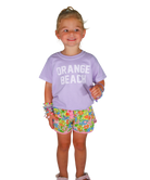 Child wearing a purple 'Orange Beach' shirt and colorful shorts on a white background