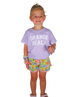Child wearing a purple 'Orange Beach' shirt and colorful shorts on a white background