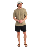 Man wearing a beige t-shirt and black shorts on a white background