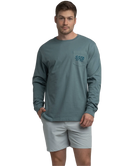 Man wearing a long-sleeve teal shirt with a logo on a white background