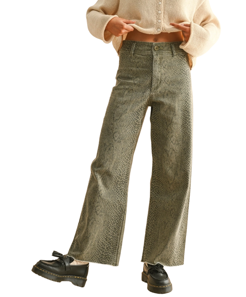 Person wearing green patterned pants and a beige cropped top on a white background