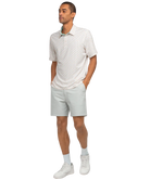 Man wearing a patterned white shirt and light gray shorts on a white background