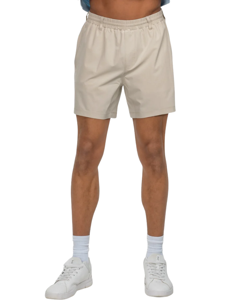 Beige shorts worn by a person on a white background