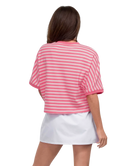 Woman wearing a pink and white striped shirt and white skirt on a white background