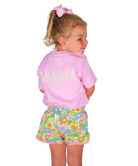 Child wearing a pink shirt with 'Shades of Pink' text and colorful floral shorts on a white background