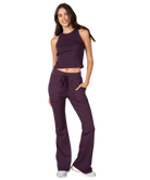 Woman wearing a purple tank and pants athleisure set outfit on a white background