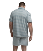 Man wearing a gray, blue, and purple striped polo shirt and shorts on a white background