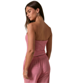 Woman wearing a RED AND WHITE STRIPED strapless top and pants on a white background