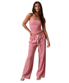 Woman wearing a RED AND WHITE STRIPED strapless top and pants on a white background