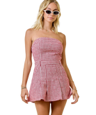 Woman wearing a red and white checkered strapless dress on a white background