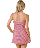 Woman wearing a red and white checkered dress on a white background