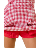 Red and white checkered shirt over red shorts on a white background