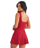 Woman wearing a red polka dot dress on a white background