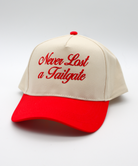 Beige and red cap with 'Never Last a Tailgate' text on a light gray background
