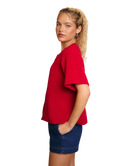 Woman wearing a red cardigan sweater and blue shorts on a white background