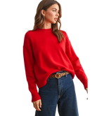 Woman wearing a red sweater and blue jeans on a white background