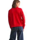 Person wearing a red sweater and blue jeans on a white background