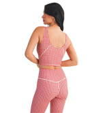 Woman wearing a red and white GINGHAM checkered tank on a white background