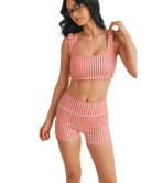 Woman wearing a red and white GINGHAM checkered tsports bra on a white backgrounD