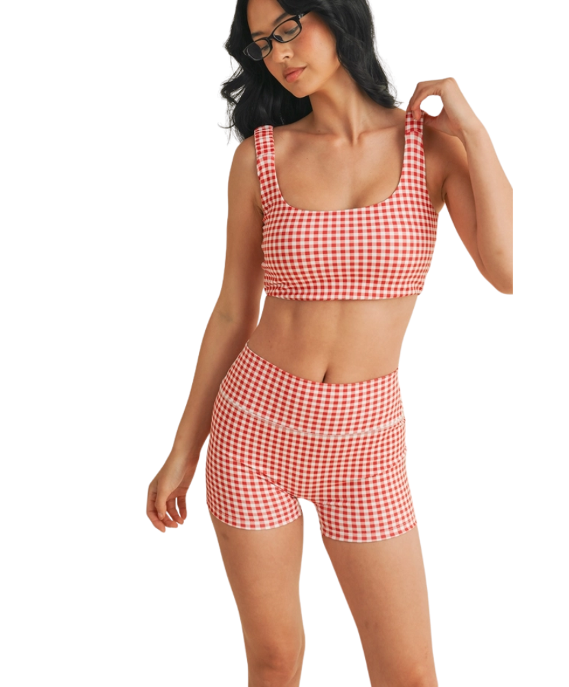 Woman wearing a red and white GINGHAM checkered tsports bra on a white backgrounD
