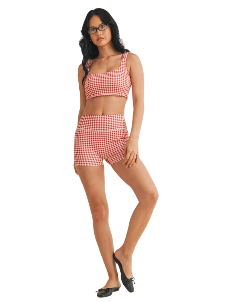 Woman wearing a red and white GINGHAM checkered tsports bra on a white backgrounD