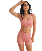 Woman wearing a red and white GINGHAM checkered tsports bra on a white backgrounD