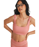Woman wearing a red and white GINGHAM checkered tsports bra on a white backgrounD