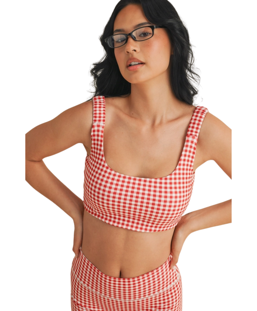 Woman wearing a red and white GINGHAM checkered tsports bra on a white backgrounD