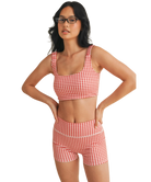 Woman wearing a red and white GINGHAM checkered tsports bra on a white backgrounD