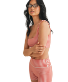 Woman wearing a red and white GINGHAM checkered tsports bra on a white backgrounD