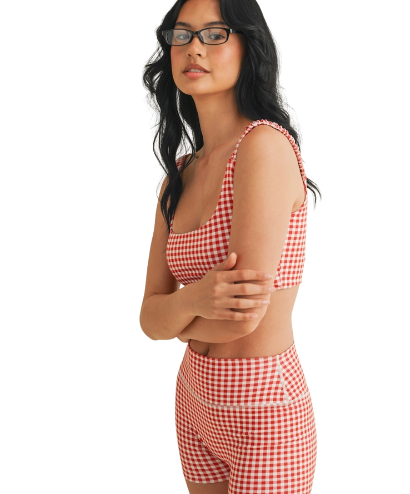 Woman wearing a red and white GINGHAM checkered tsports bra on a white backgrounD