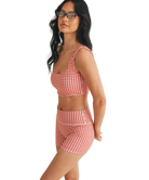 Woman wearing a red and white GINGHAM checkered tsports bra on a white backgrounD