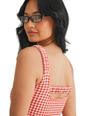 Woman wearing a red and white GINGHAM checkered tsports bra on a white backgrounD