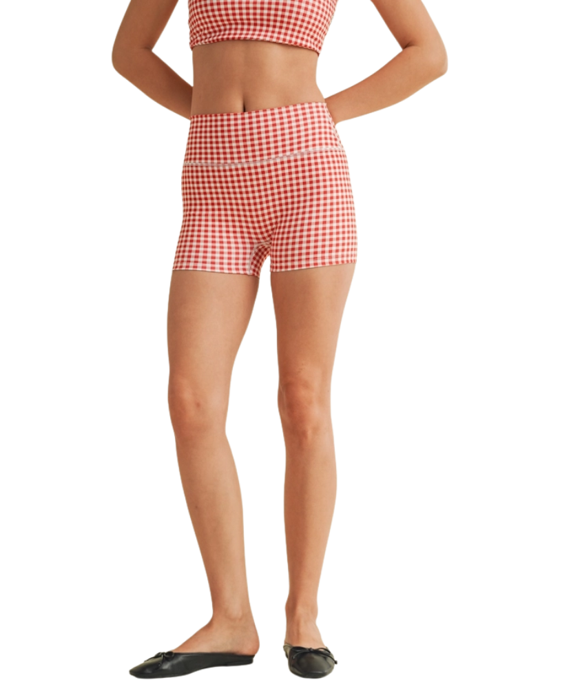 Woman wearing a red and white gingham checkered shorts on a white background
