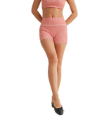 Woman wearing a red and white gingham checkered shorts on a white background