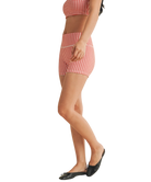 Woman wearing a red and white gingham checkered shorts on a white background