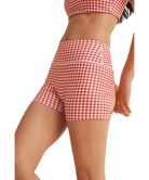 Woman wearing a red and white gingham checkered shorts on a white background