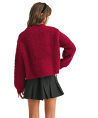 Woman wearing a red cardigan on a white background