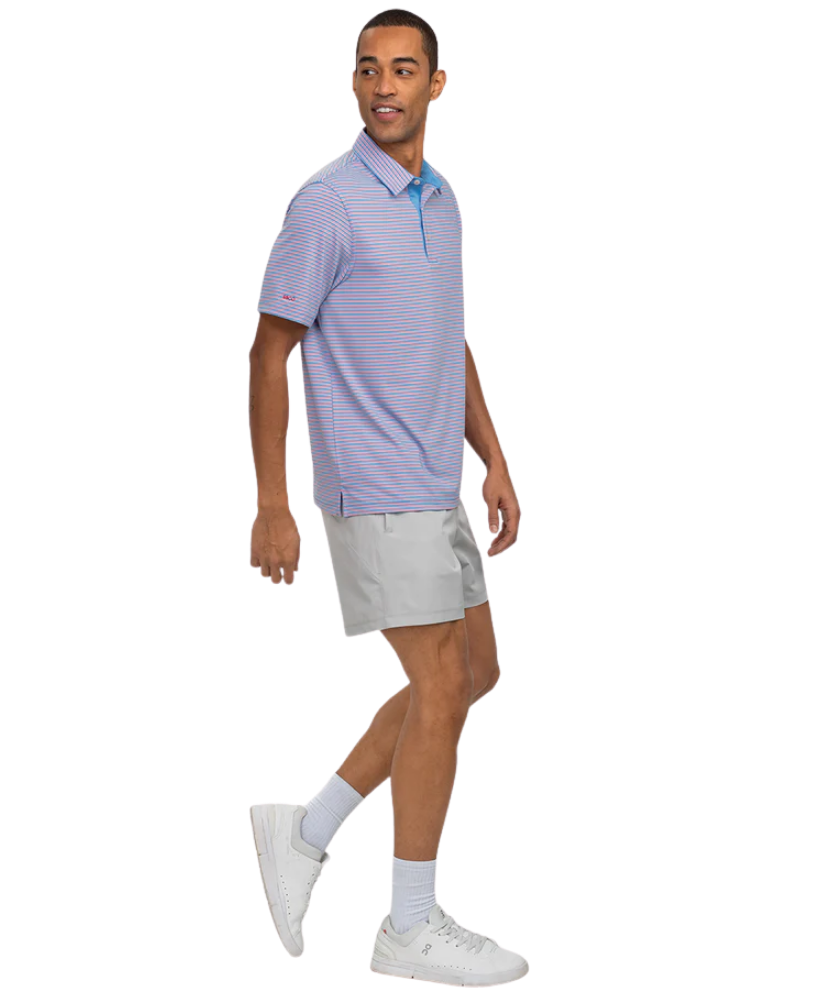 Man wearing a Southern Shirt Co light purple striped polo shirt and gray shorts on a white background