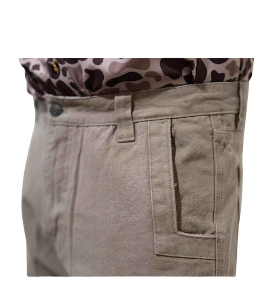 Close-up of beige pants with a patterned shirt underneath on a white background