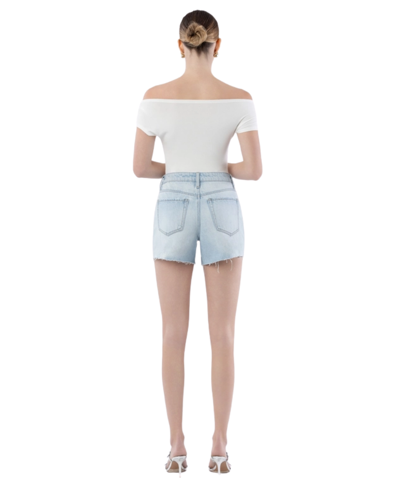 Woman wearing light blue denim shorts on a white background
