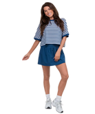 Woman wearing a blue and white striped top and skirt on a white background