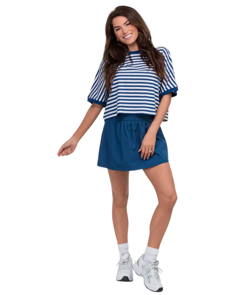 Woman wearing a blue and white striped top and skirt on a white background