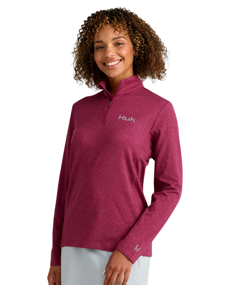 Woman wearing a maroon heather Huk pullover on a white background