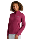 Woman wearing a maroon heather Huk pullover on a white background