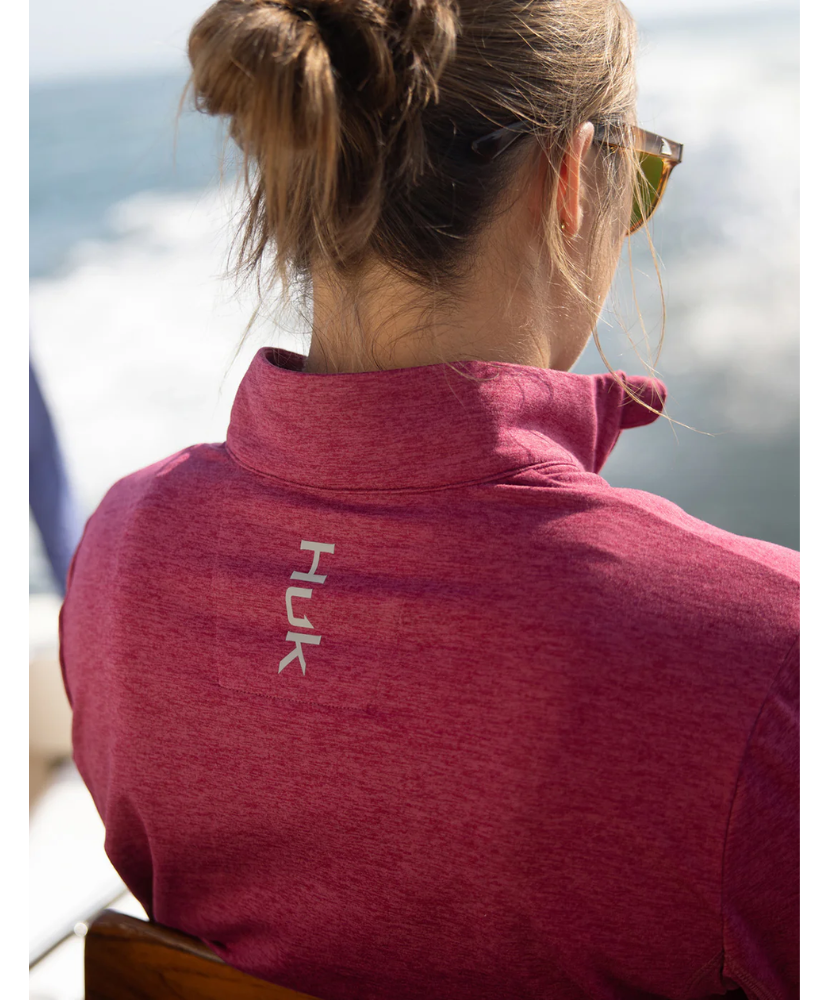 Woman wearing a maroon heather Huk pullover on a white background