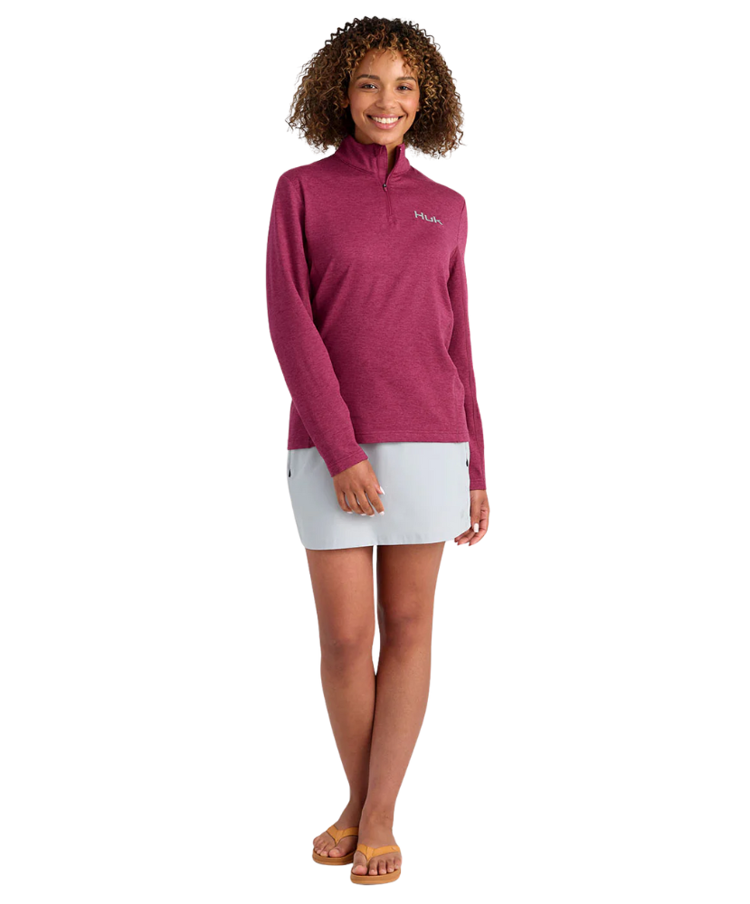 Woman wearing a maroon heather Huk pullover on a white background