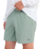 Person wearing LIGHT GREEN HUK shorts on a white background